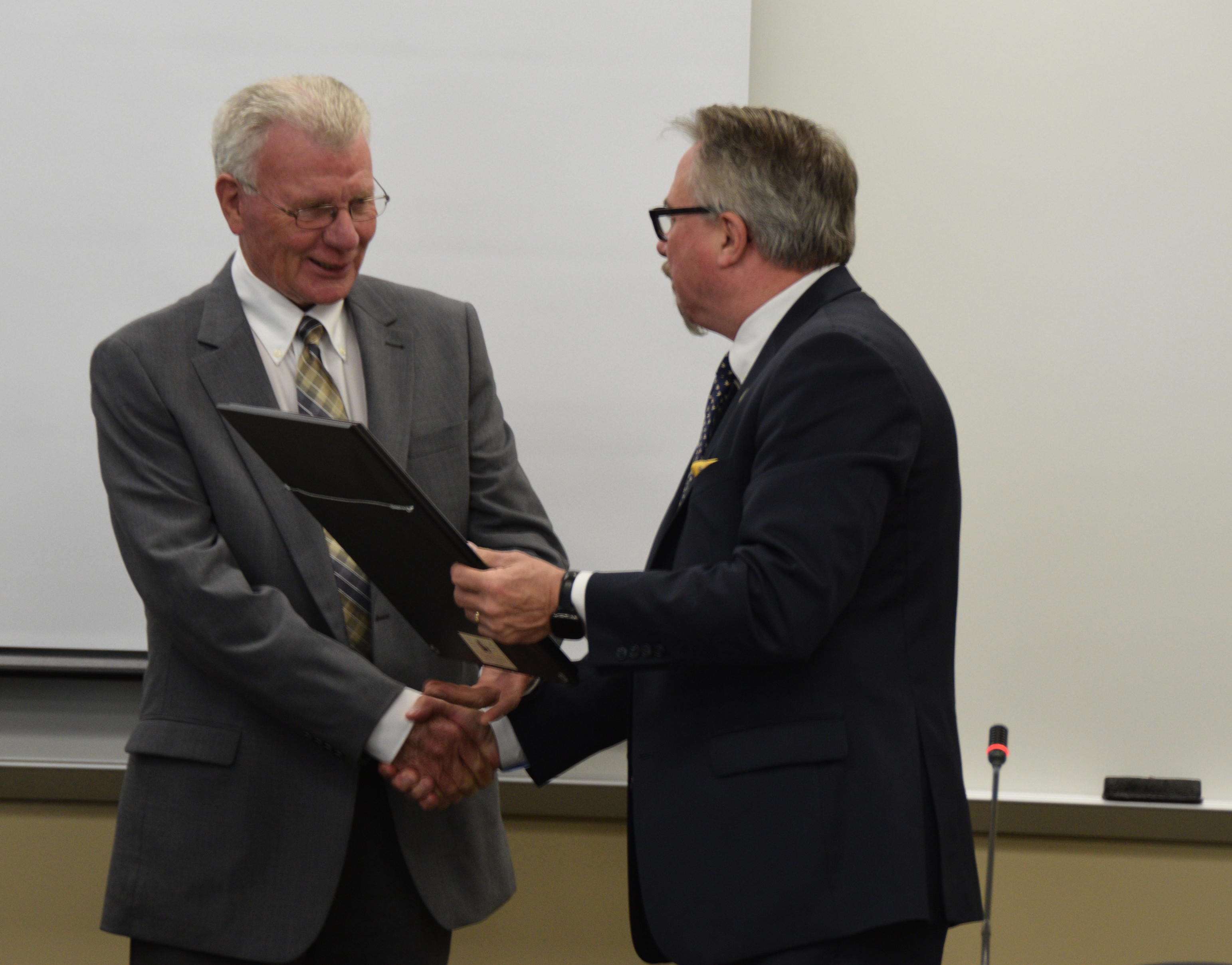 VU President Dr. Chuck Johnson presents Trustee George Ridgway with a resolution of appreciation