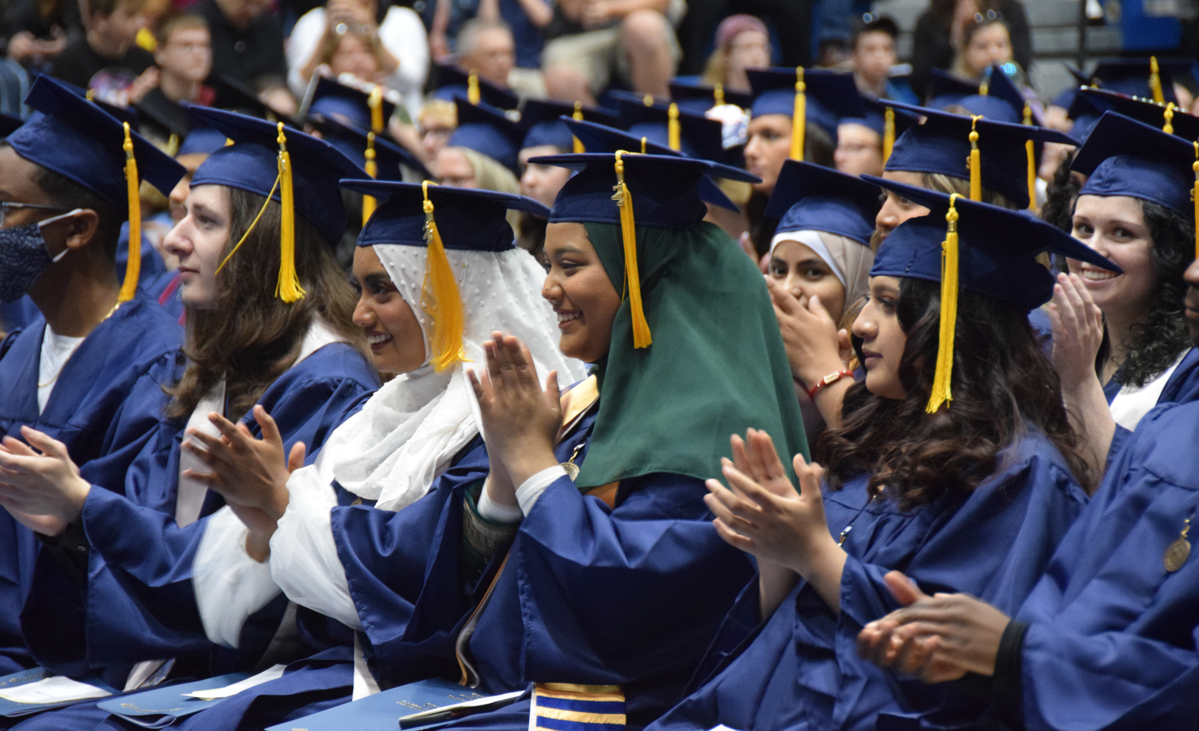 Class of 2022 VU graduates clapping and wearing caps and gowns during Spring 2022 Commencement at P.E. Complex